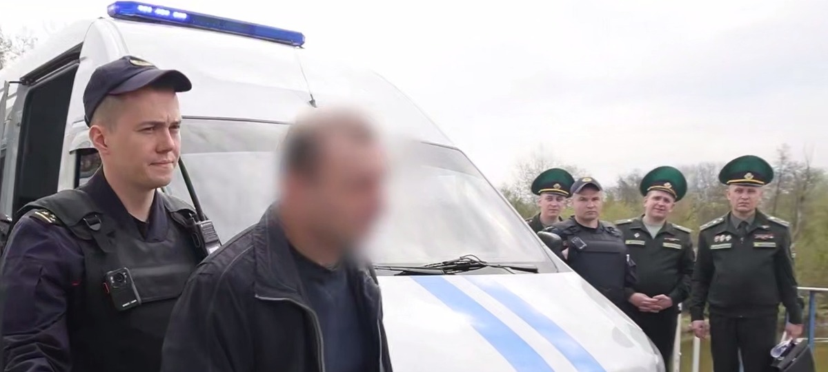 Беларуские милиционеры передают мужчину польским полицейским. Скриншот видео МВД