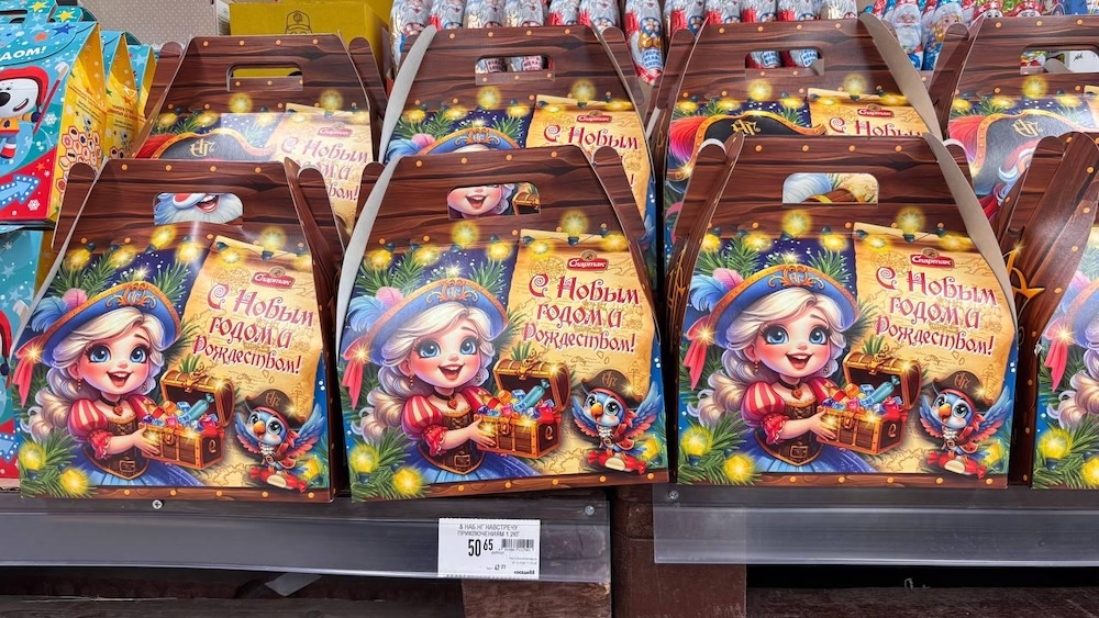 Новогодние сладкие подарки на полках в магазине.